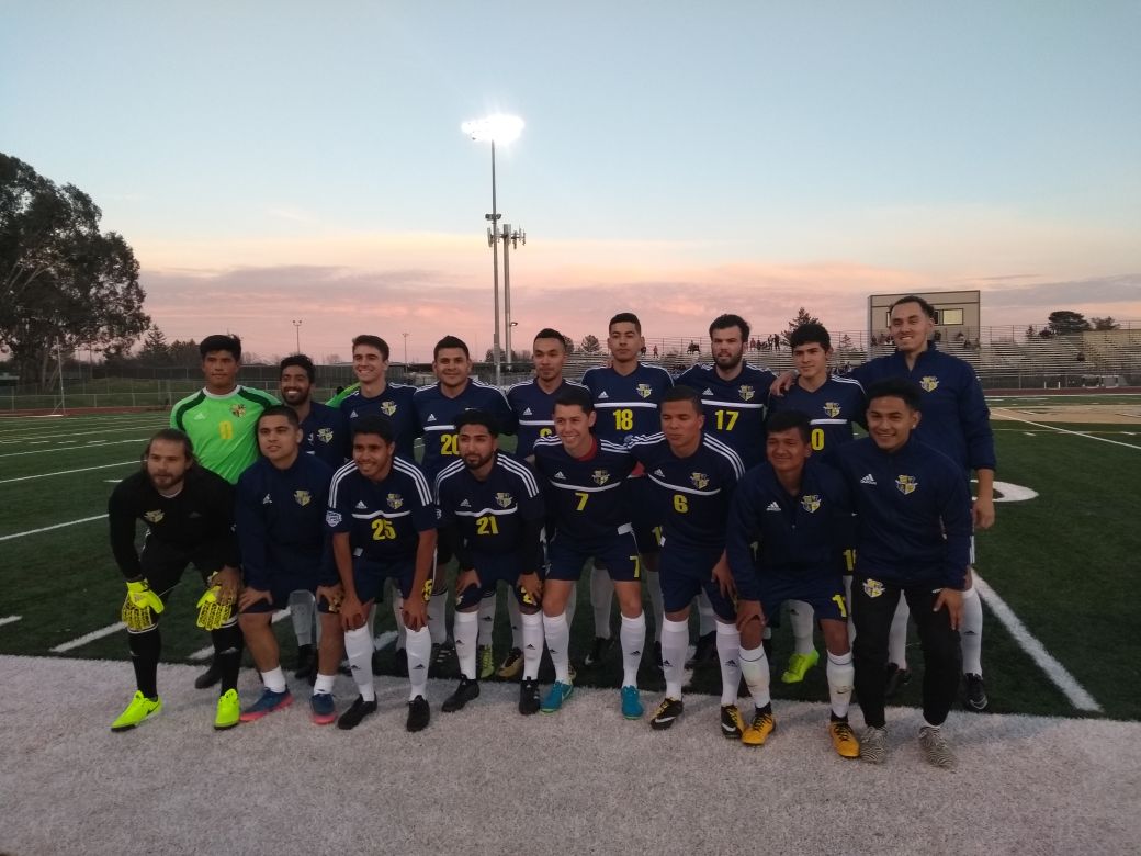 Cal Victory FC team in navy kits gathering for a match at dusk