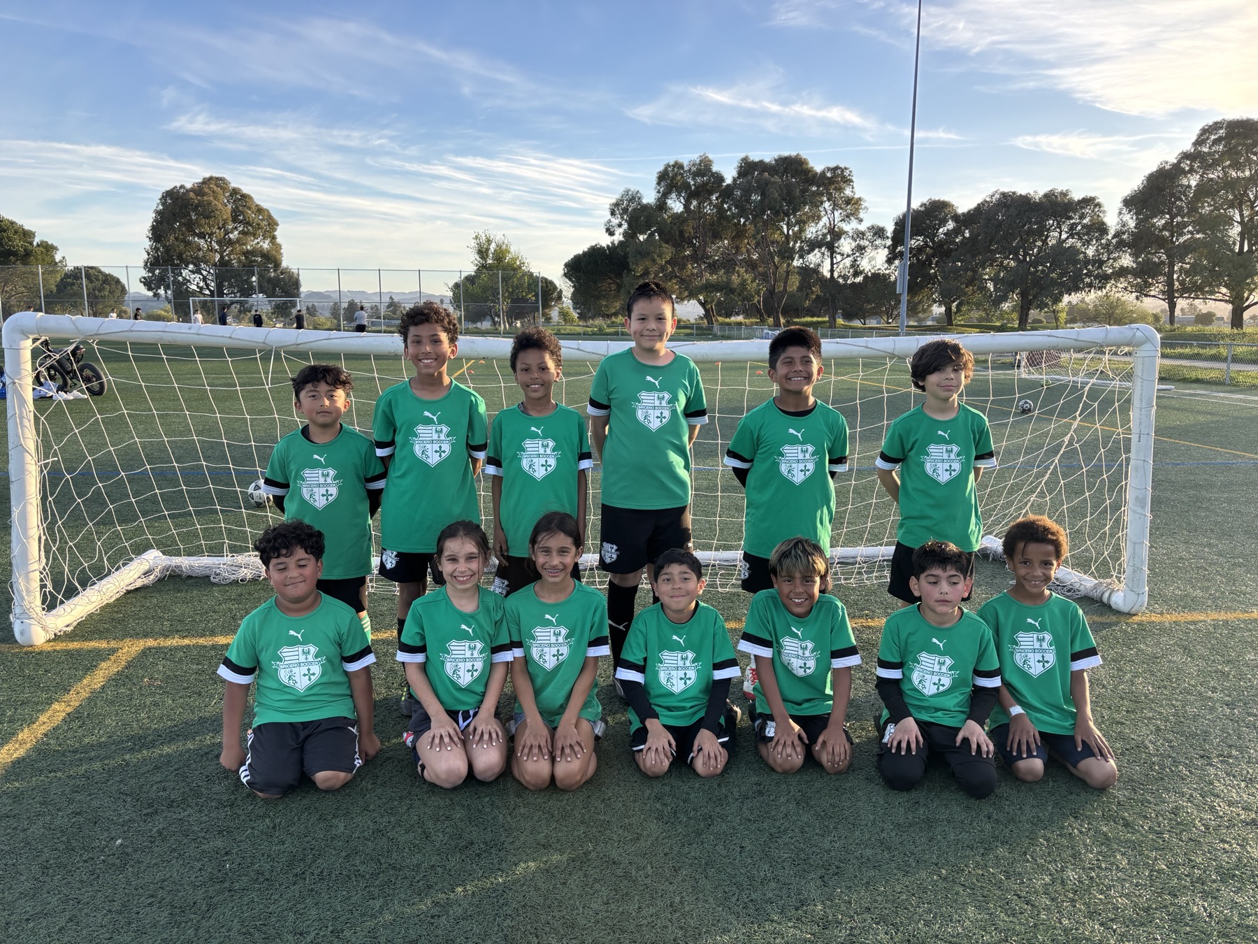 Cal Victory FC youth academy players posing together on the field